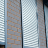 Residential roller shutters in a warm sunset light, adding a touch of elegance and security to a home exterior.