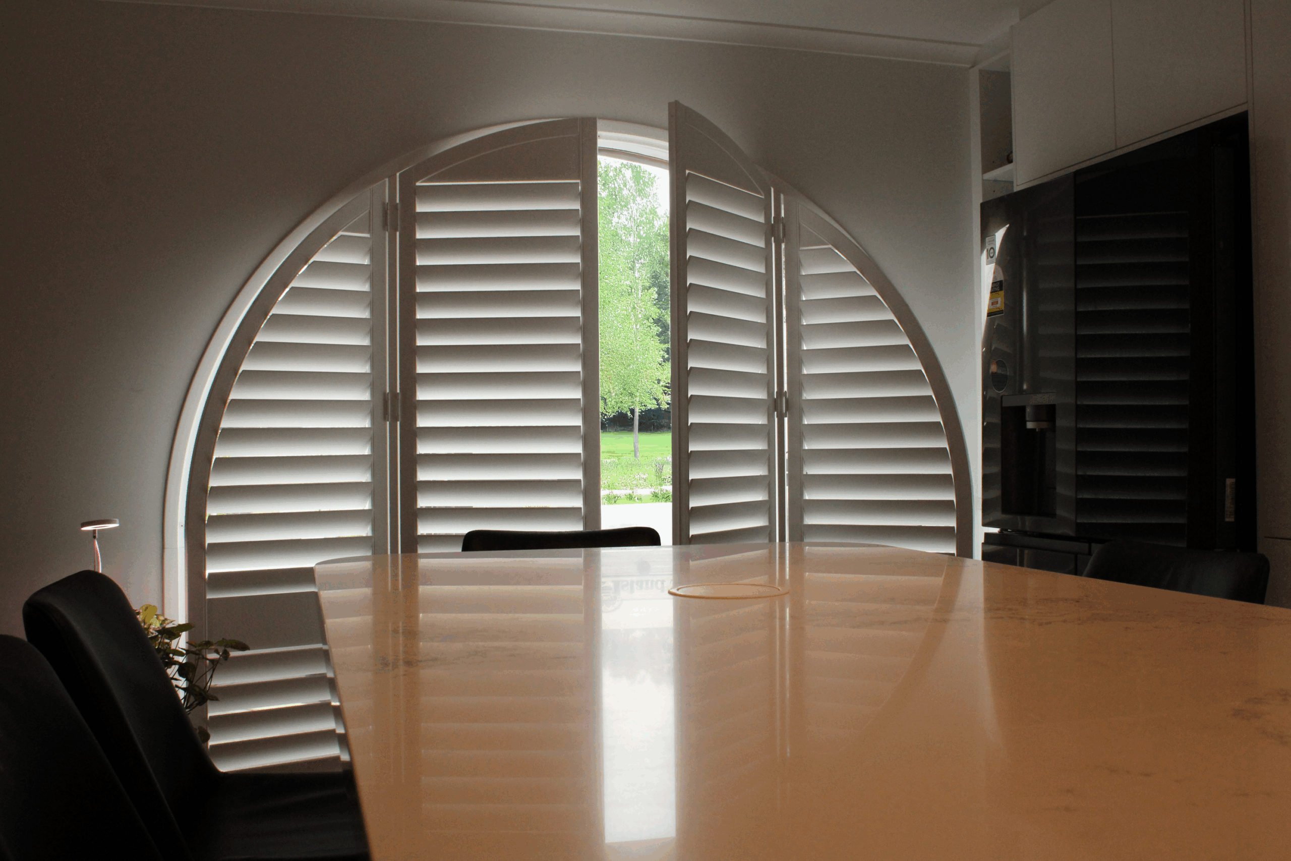 Arc plantation shutters